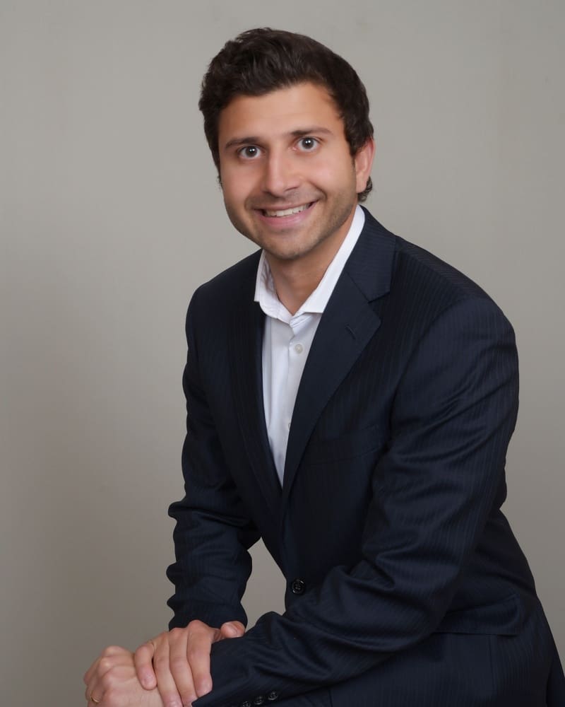 A man in a suit and tie smiling for the camera.