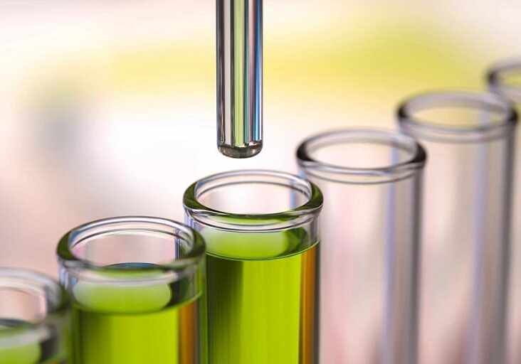 A close up of some green liquid in glass containers